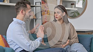 Serious Man Talking to Woman While Sitting on Sofa