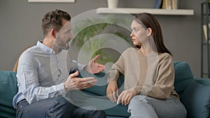 Serious Man Talking to Woman While Sitting on Sofa