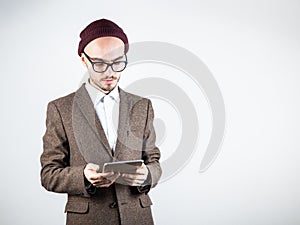 Serious man in tweed jacket with a tablet computer.