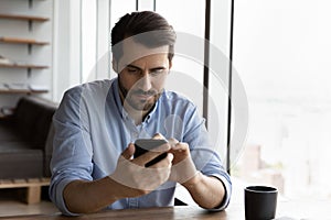 Serious man use smartphone gadget texting online