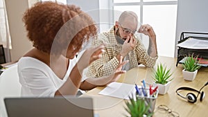 Serious man and woman coworkers stressed out, working together on laptop at office table