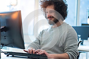 Serious manager working on a laptop in his modern office