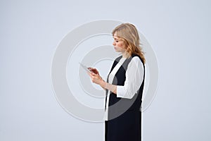 Serious mature blond using digital tablet