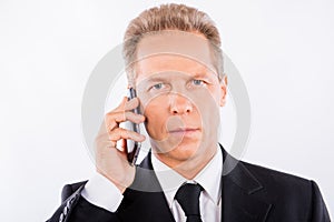 A serious mature businessman with modern mobile phone