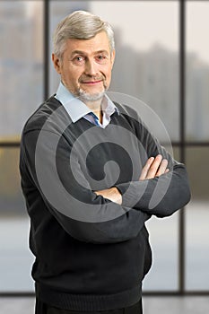 Serious mature man with crossed arms.