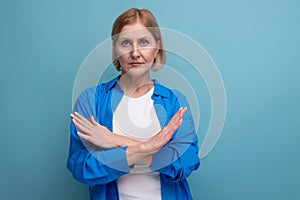 serious mature woman disagree on blue background with copyspace