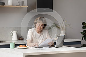 Serious middle aged landlady, homeowner woman calculating income