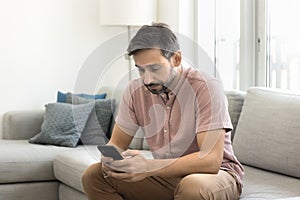 Serious middle aged man using smart application on smartphone