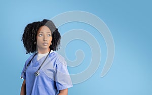 Serious millennial african american woman in uniform with stethoscope looking at empty space