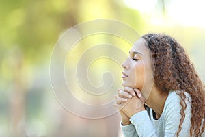 Serious mixed race woman meditating outdoors