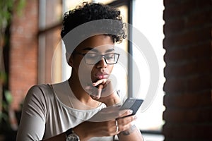 Serious mixed race woman surfing internet using phone