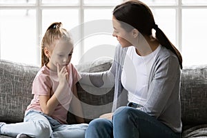 Serious mother talking to sad upset preschooler daughter