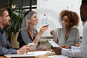 Concentrated teammates discussing startup research results at office.