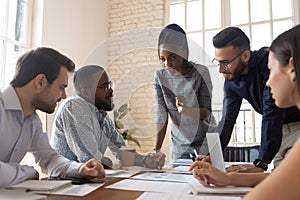 Serious multiracial corporate business team discuss paperwork at group briefing