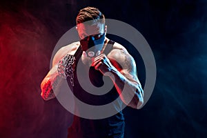 Serious muscular fighter doing the punch with the chains braided over his fist.