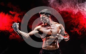 Serious muscular fighter doing the punch with the chains braided over his fist.