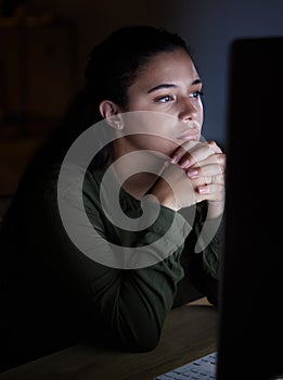 Serious, night and woman on computer in office, working late on online project, proposal and planning. Concentration