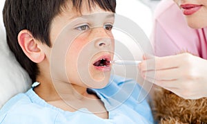 Serious nurse taking child's temperature