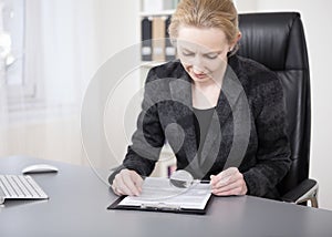 Serious Office Woman Reading with Magnifying Glass