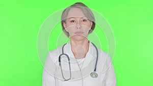 Serious Old Female Doctor on Green Background