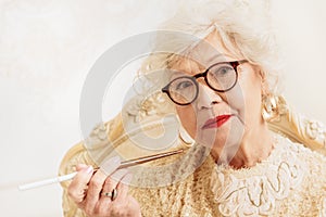 Serious old woman smoking cigarette