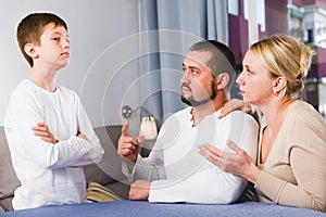 Serious parents scolding son