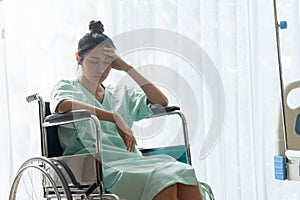 Serious patient sitting on wheelchair in hospital. photo