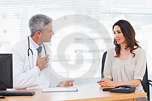 Serious patient talking with her doctor about illness