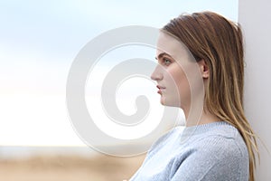 Serious pensive woman looking away on the beach