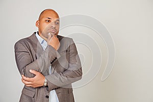 Serious pensive worried african man male, touching chin, looking to the side, thinking about solution for inspiration