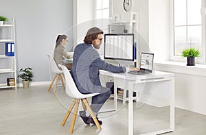 Two professional financial accountants working on computers in modern office interior