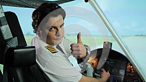 Serious pilot making thumbs up gesture at camera, recommending reliable airline