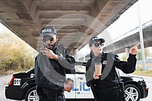 Serious policewoman pointing with finger near