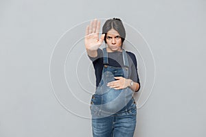 Serious pregnant lady make stop gesture
