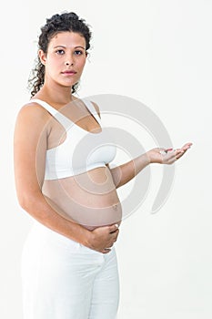 Serious pregnant woman holding pills