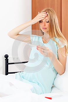 Serious pregnant woman with pregnancy test