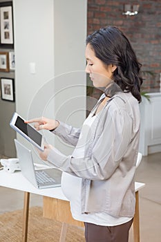 Serious pregnant woman using tablet