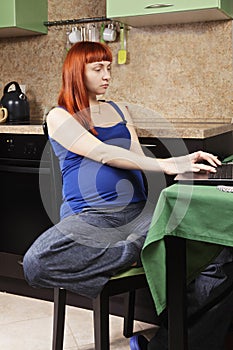 Serious pregnant woman working at home