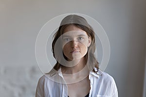 Serious pretty freckled young woman front head shot indoor portrait