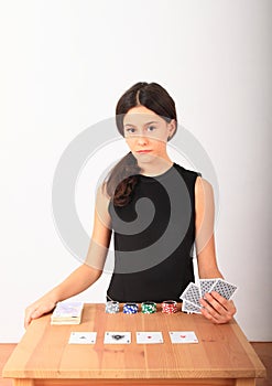 Serious pretty girl - kid playing poker with money