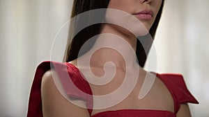 Serious pretty woman wearing red dress, waiting for boyfriend, anticipation