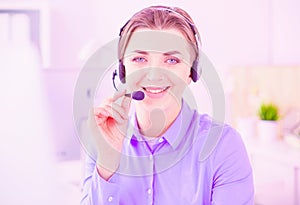 Serious pretty young woman working as support phone operator with headset in office