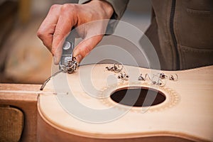 Serious professional guitar-maker working with unfinished guitar at workshop