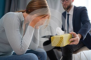 Serious psychologist listen to crying female patient in clinic, cropped close-up. Professional medical care, patient