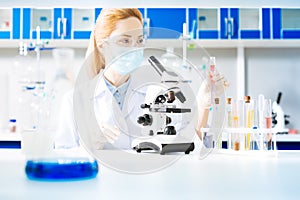 Serious researcher raising her arm with tube