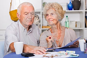 Serious retired couple calculating bills