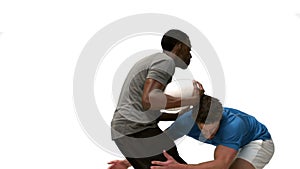 Serious rugby players tackling for ball