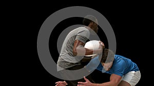 Serious rugby players tackling for ball