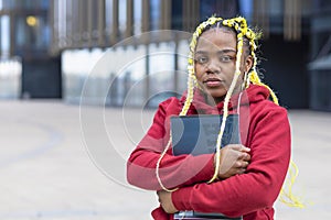 Serious sad african american girl near college. black student with book at university before exam.