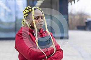 Serious sad african american girl near college. black student with book at university before exam.